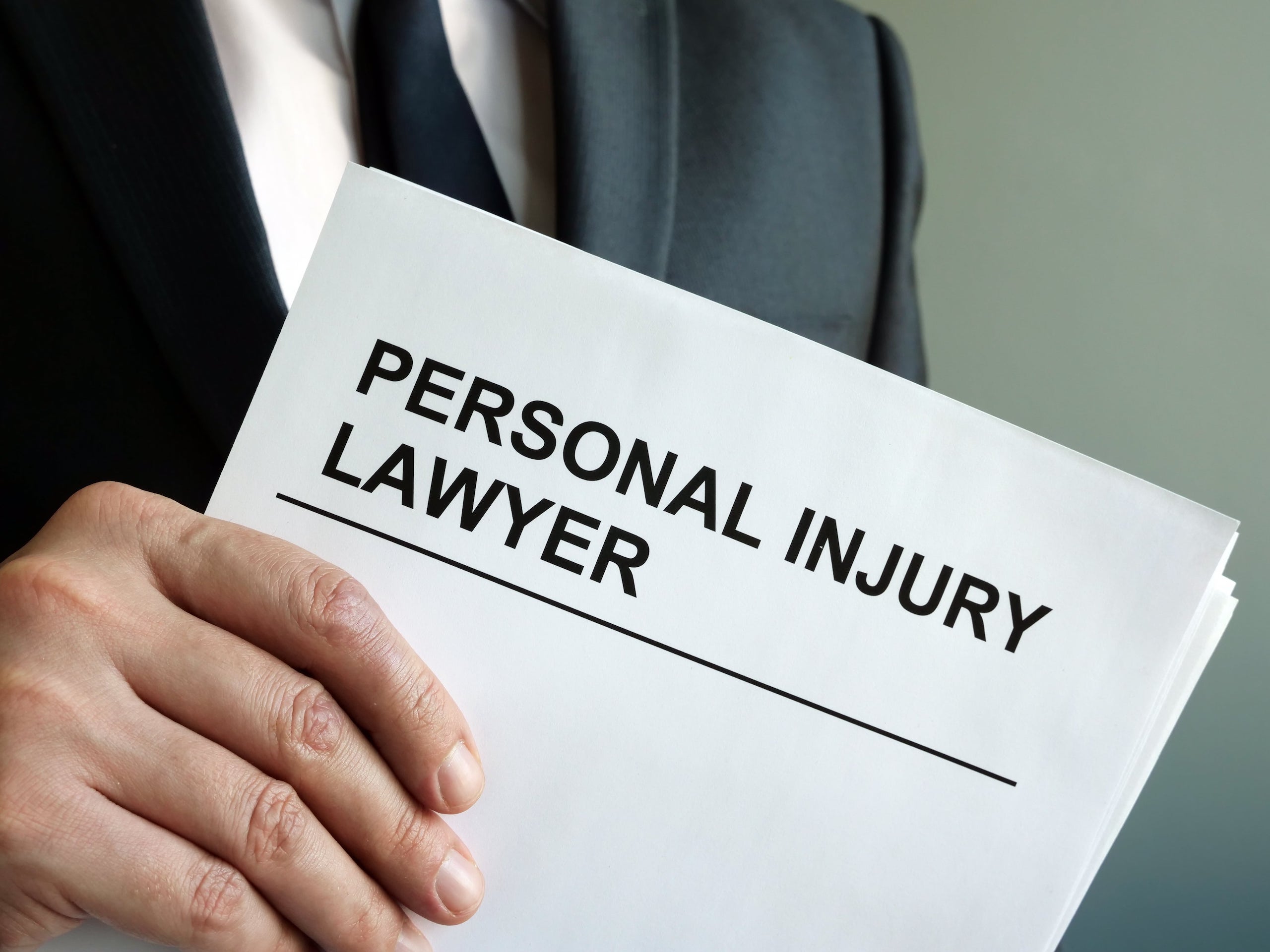 Personal Injury Lawyer Holding Documents with Their Title Visible