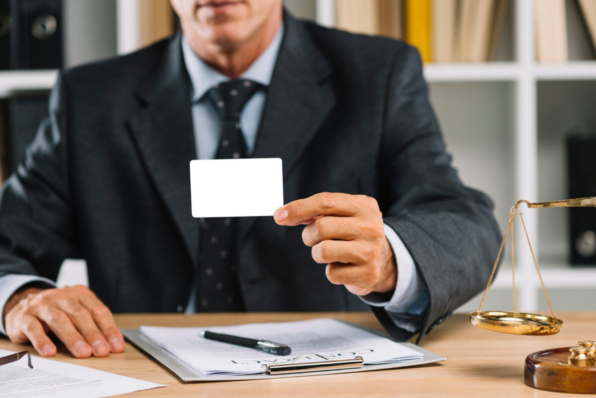 Abogados de accidentes mostrando tarjeta.
