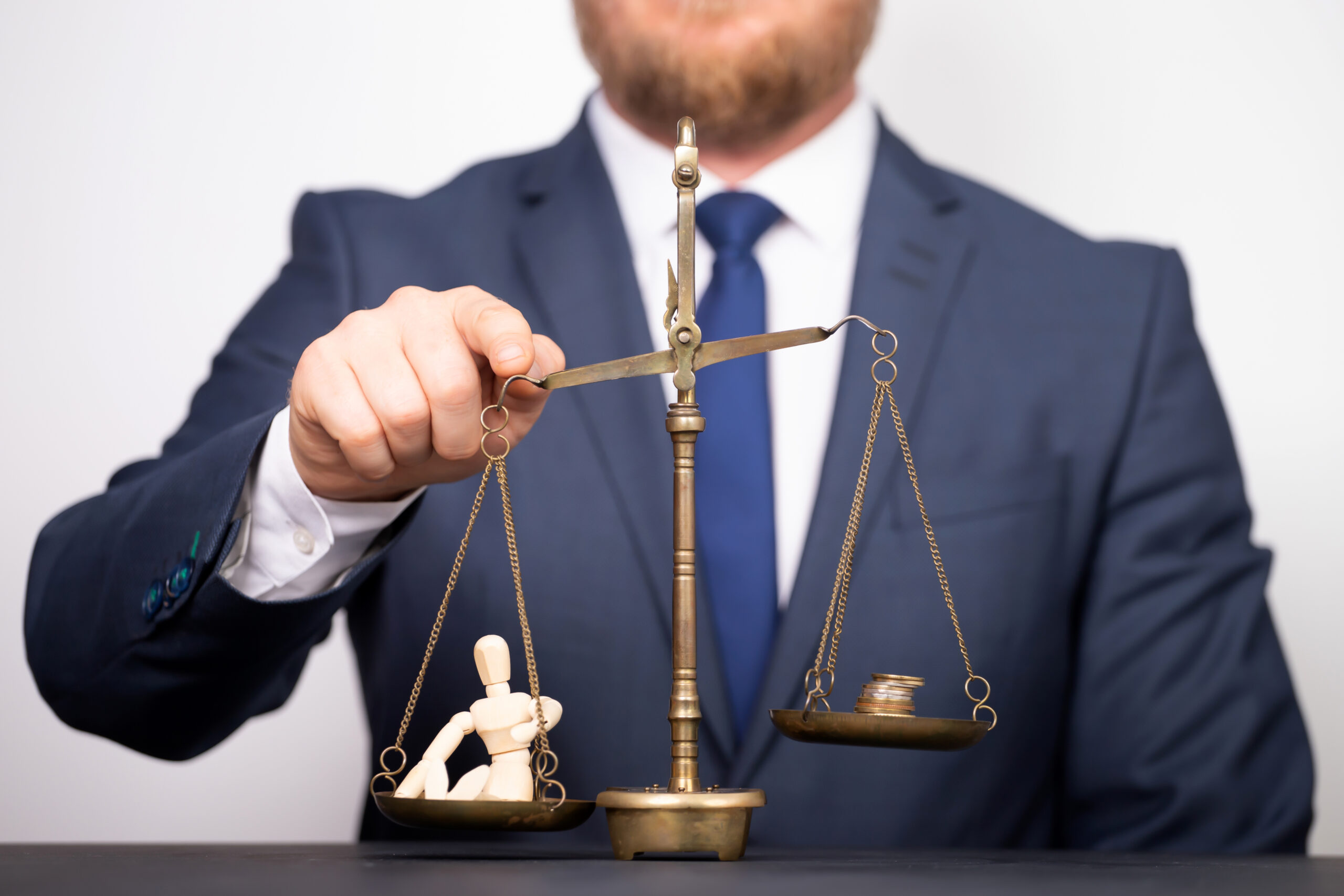 Insurance Claim Dispute Lawyers represented in a photo of scale with people on one pan and money on the other, showing balance